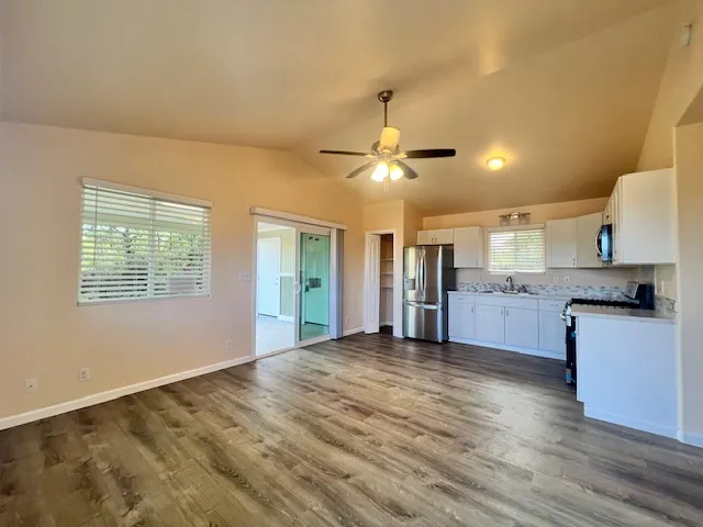 a view of a kitchen with a sink dishwasher and a kitchen island with wooden floor