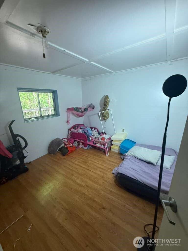 1671 Northeast Mission Creek Road Belfair, WA 98528 - Photo 29 of 31 a bedroom with a bed and a chandelier