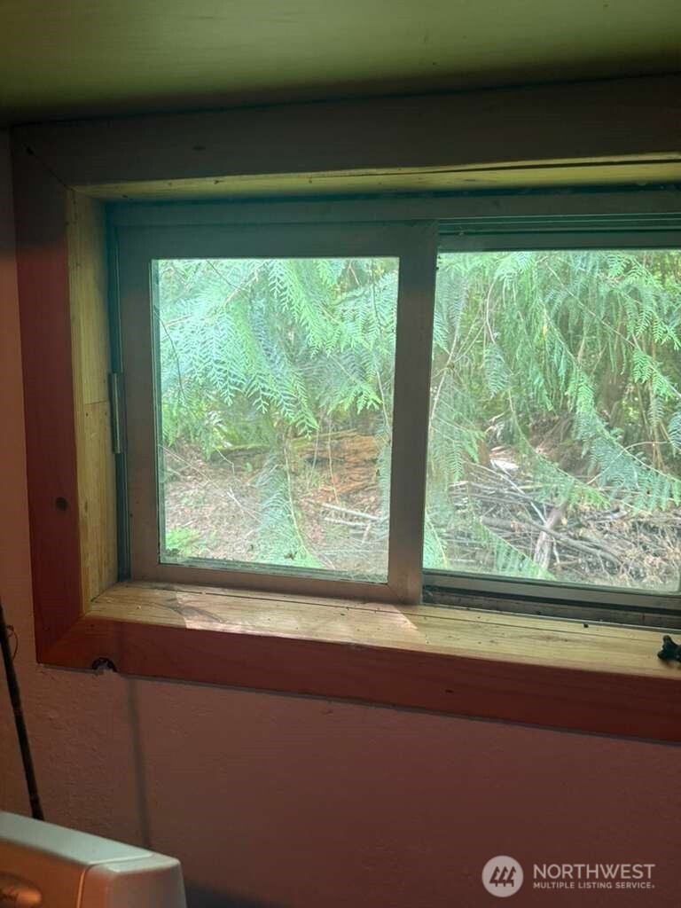 1671 Northeast Mission Creek Road Belfair, WA 98528 - Photo 6 of 31 a view of a room that has a window and a bed