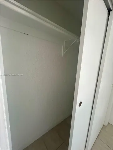 a view of a backyard with large trees and wooden fence