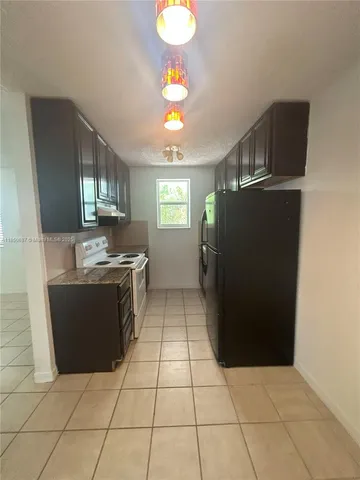 a kitchen with granite countertop a refrigerator and a stove