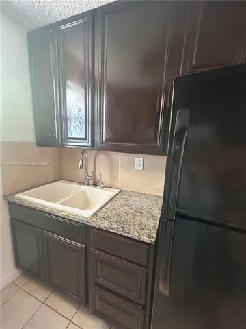 a bathroom with a granite countertop sink and washing machine
