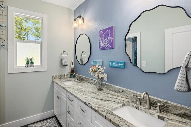 a spacious bathroom with a granite countertop tub sink and mirror