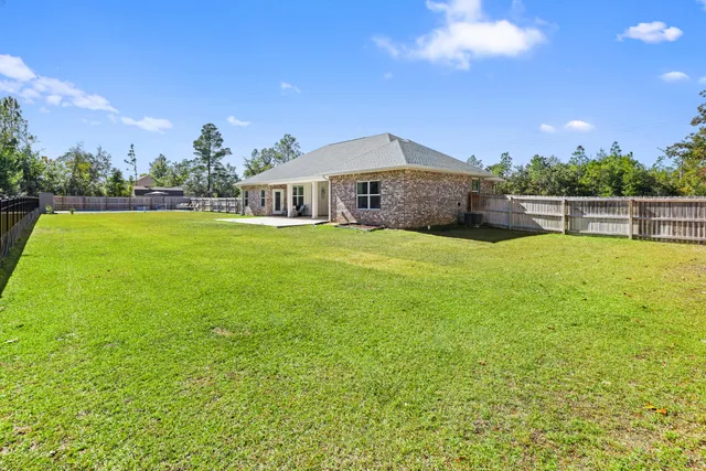 a view of a house with swimming pool and a yard
