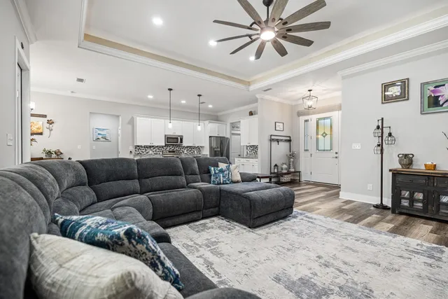 a kitchen with a stove a sink dishwasher a dining table and chairs with wooden floor