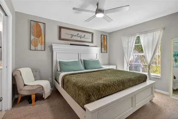 a bed sitting in a bedroom next to a window