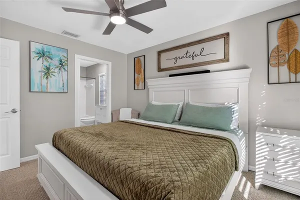 a large bed sitting in a bedroom and painting on the wall