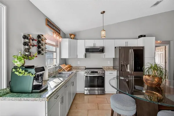 a kitchen with kitchen island granite countertop stainless steel appliances a sink a counter top space cabinets and a counter top space