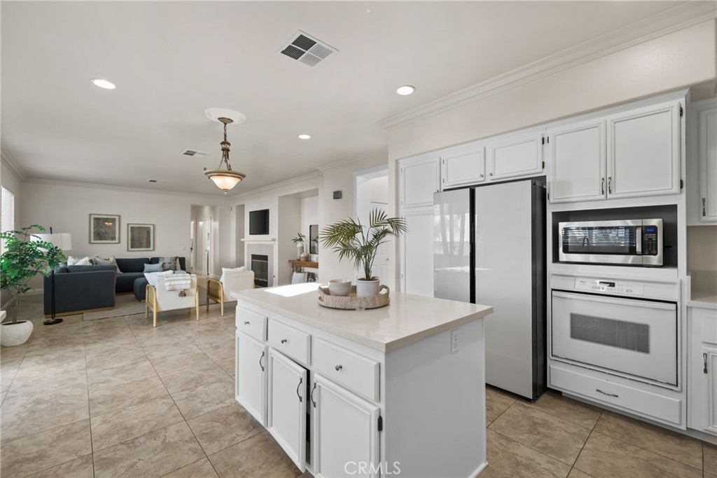 6124 Risingstar Drive Eastvale, CA 92880 - Photo 12 of 37 a kitchen with white cabinets and stainless steel appliances