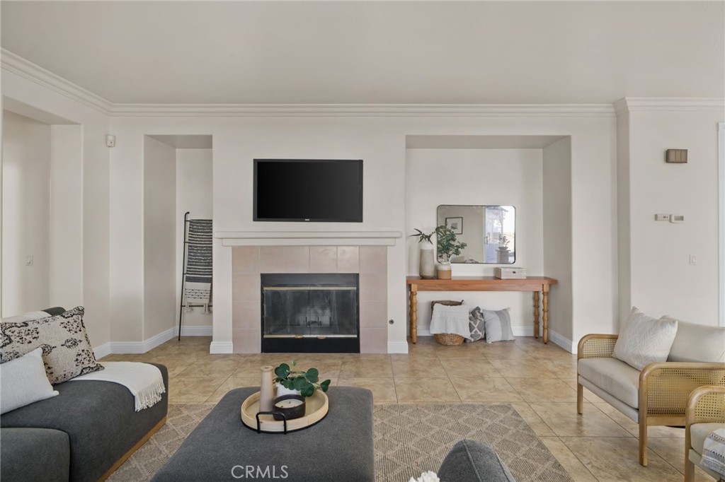 6124 Risingstar Drive Eastvale, CA 92880 - Photo 15 of 37 a living room with furniture a fireplace and a flat screen tv