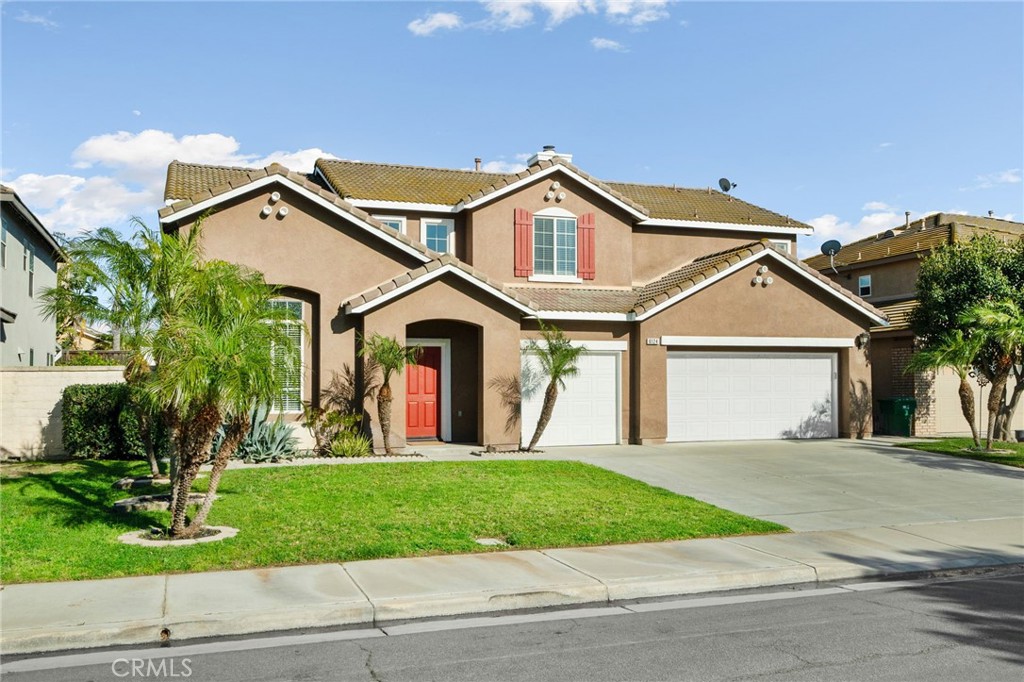 6124 Risingstar Drive Eastvale, CA 92880 - Photo 2 of 37 a front view of a house with a yard and garage