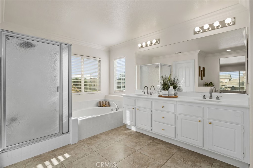 6124 Risingstar Drive Eastvale, CA 92880 - Photo 27 of 37 a spacious bathroom with a tub sink shower and mirror