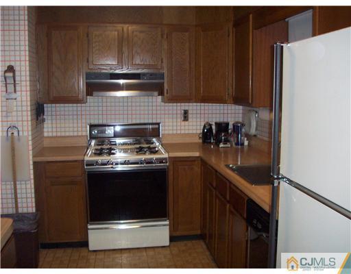 18 Hamlin Road East Brunswick, NJ 08816 - Photo 8 of 10 a kitchen with granite countertop stainless steel appliances and wood cabinets
