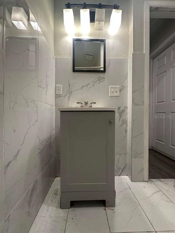 322 North Wekiwa Springs Road, Unit B Apopka, FL 32703 - Photo 15 of 15 a bathroom with a sink a large mirror and a shower