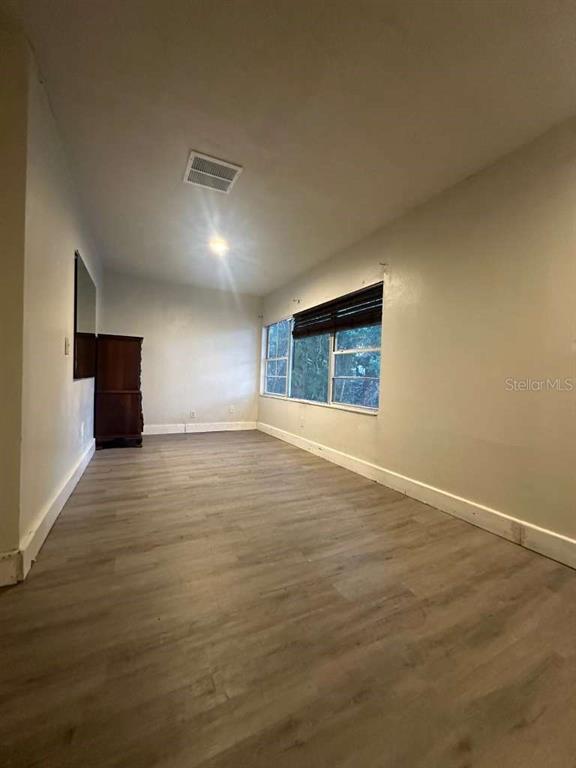 322 North Wekiwa Springs Road, Unit B Apopka, FL 32703 - Photo 8 of 15 a view of an empty room with window and wooden floor