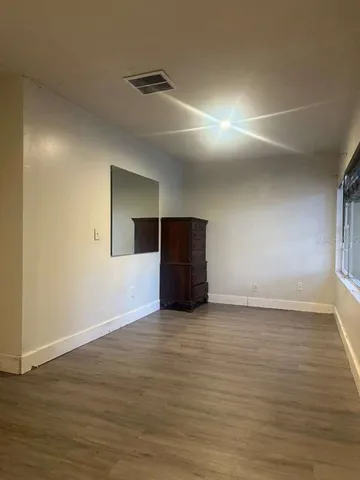 a view of an empty room with wooden floor