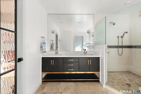 a bathroom with double vanity sink and a mirror