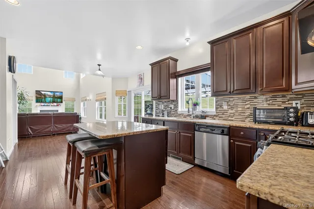 a kitchen with stainless steel appliances granite countertop wooden cabinets a sink and a stove