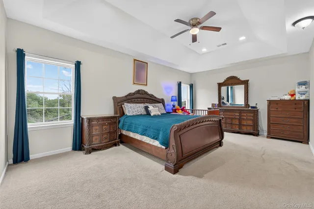a spacious bedroom with a bed and a chandelier