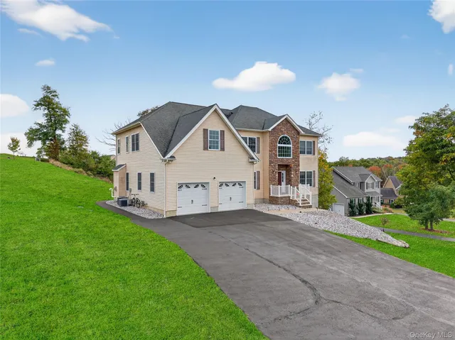 a view of a house with a big yard and large trees