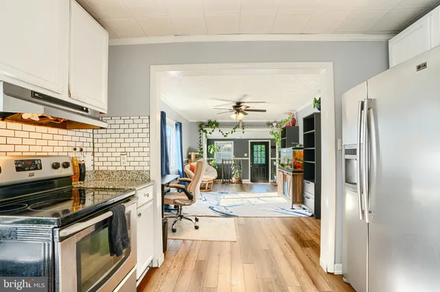 a kitchen with stainless steel appliances a stove a refrigerator and wooden cabinets