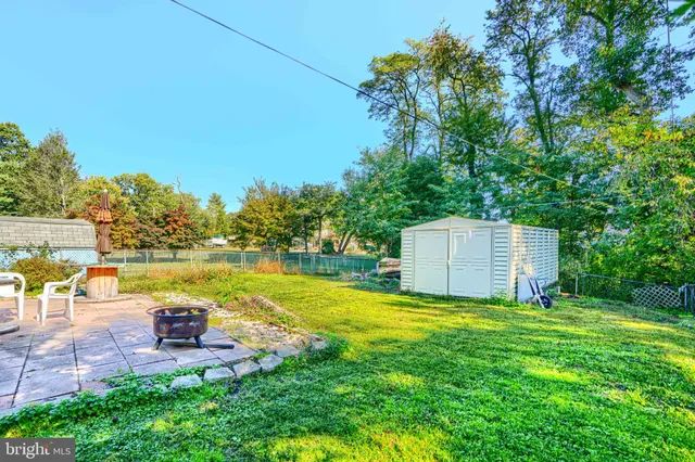 a view of a house with a yard and a large tree