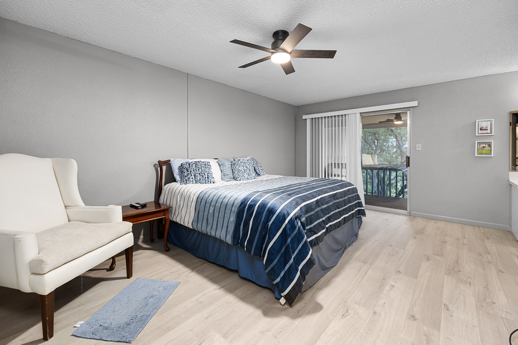 229 Comanche Lane Point Venture, TX 78645 - Photo 24 of 38 a spacious bedroom with a bed and a chandelier