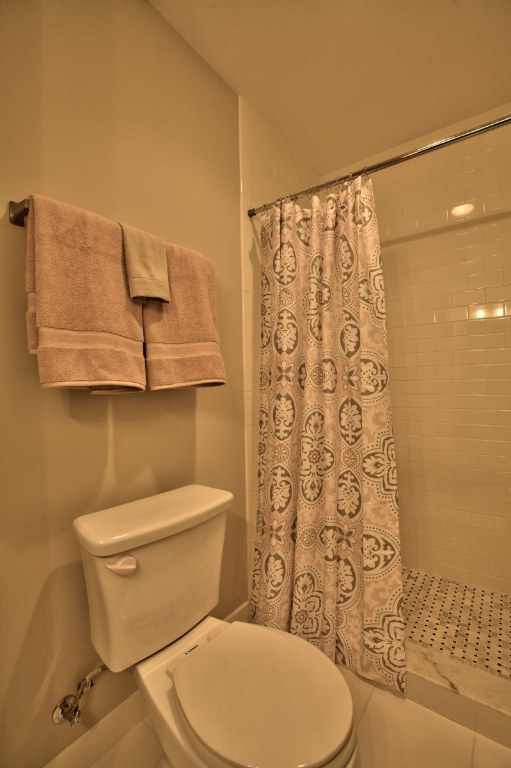 924 East 51st Street, Unit 108 Austin, TX 78751 - Photo 6 of 30 a white toilet sitting next to a shower curtain