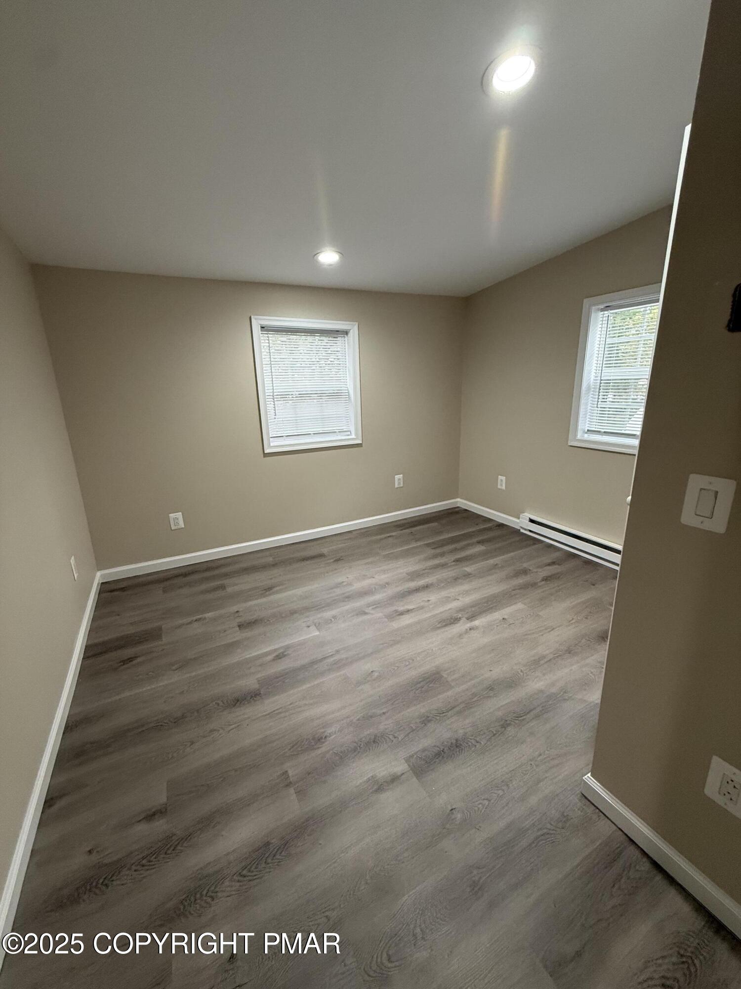 1114 Mill Street, Unit 2 Tobyhanna, PA 18466 - Photo 11 of 21 an empty room with wooden floor and windows