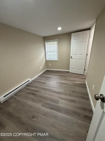 a view of an empty room with wooden floor