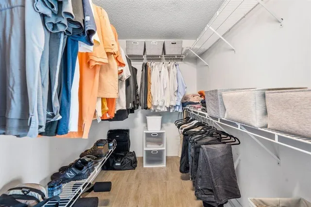 a view of walk in closet with clothes and shoes
