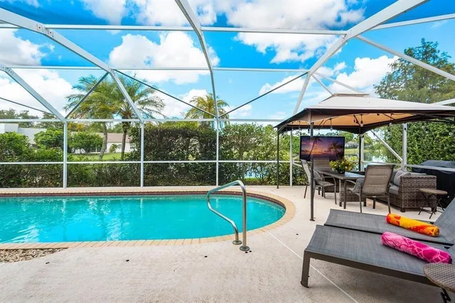 a view of a swimming pool with a patio and a backyard
