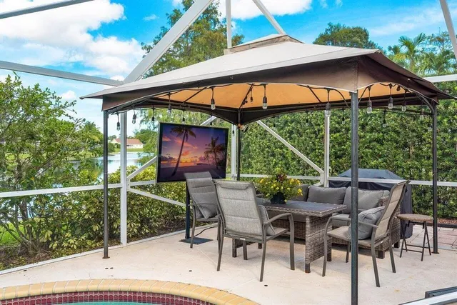 a view of patio with table and chairs under an umbrella
