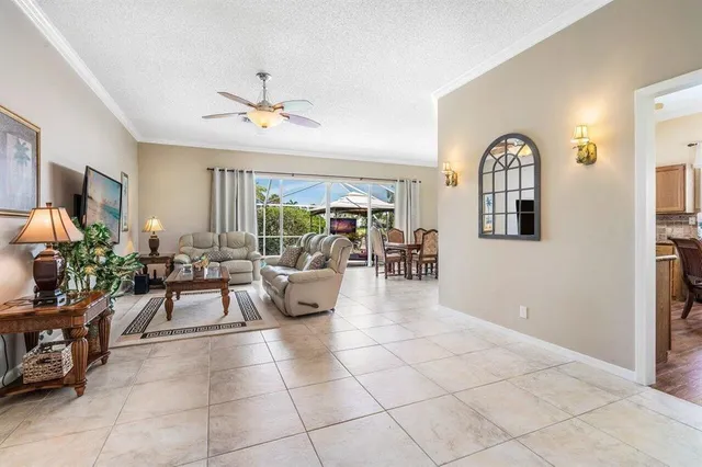 a living room with furniture a chandelier and a view of kitchen