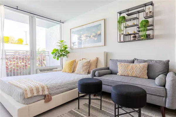 a bedroom with a bed couch and painting on the wall
