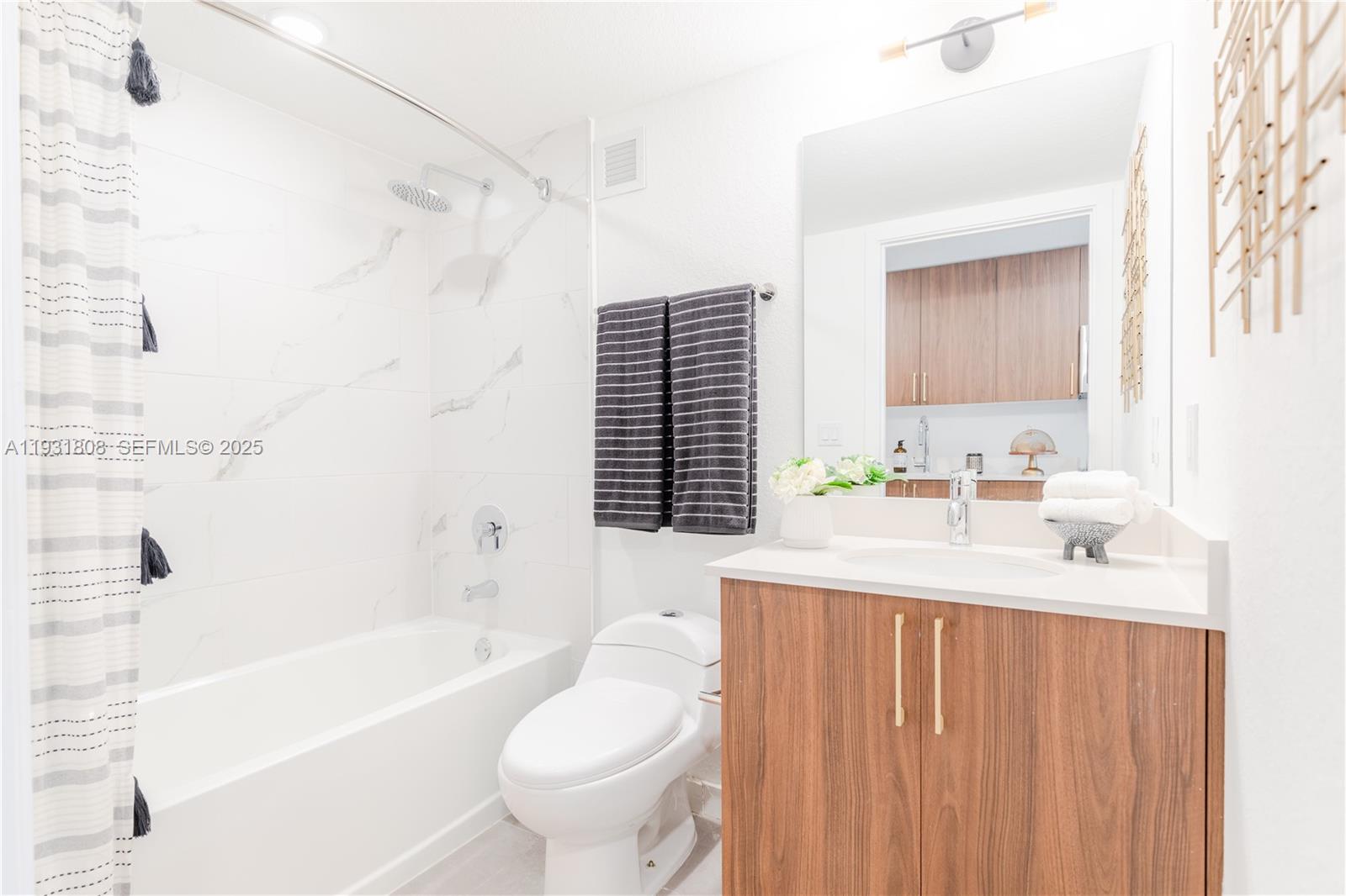 1950 West 49th Street, Unit 155 Hialeah, FL 33012 - Photo 7 of 39 a bathroom with a sink a toilet a mirror a bathtub and shower