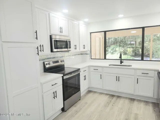 a kitchen with appliances cabinets and a sink