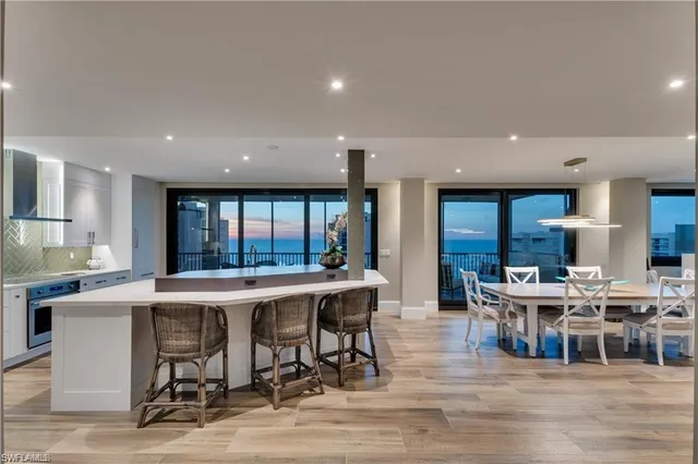 a dining hall with stainless steel appliances a dining table and chairs with wooden floor