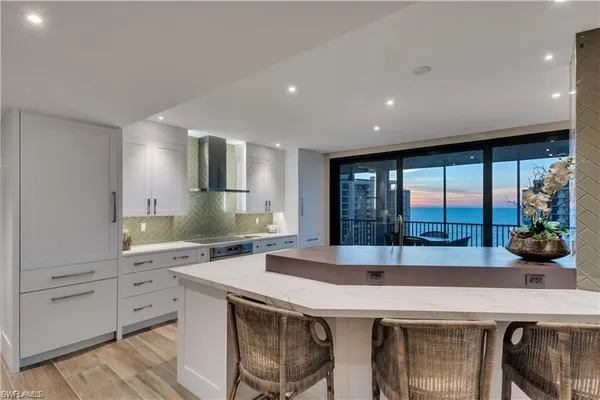 a dining hall with stainless steel appliances granite countertop a dining table chairs and view of kitchen