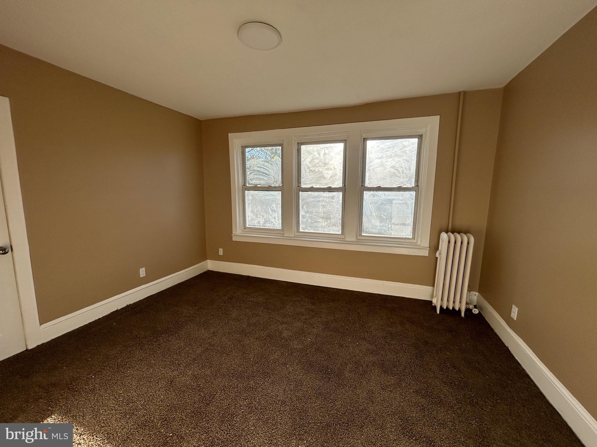 1428 West State Street Trenton, NJ 08618 - Photo 14 of 26 an empty room with a fireplace and windows