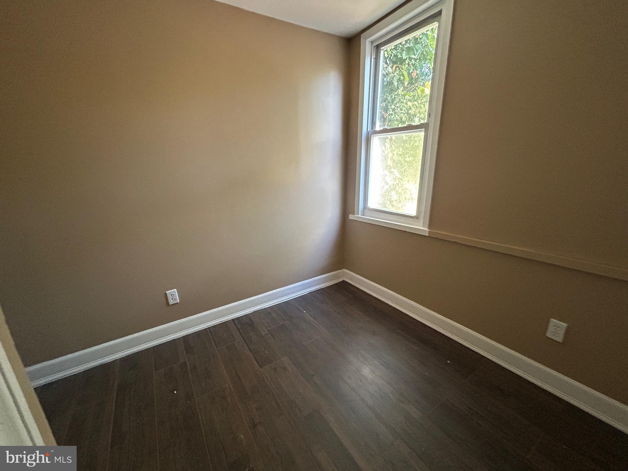 1428 West State Street Trenton, NJ 08618 - Photo 21 of 26 a view of an empty room with wooden floor and a window