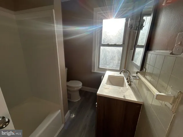 a bathroom with a sink a toilet and a window