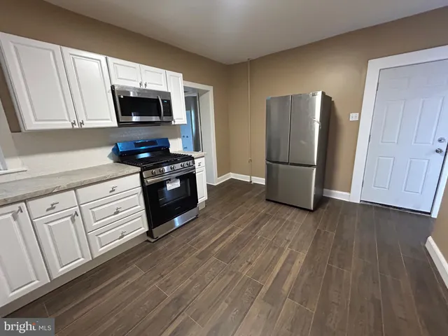 a kitchen with a refrigerator stove and wooden cabinets