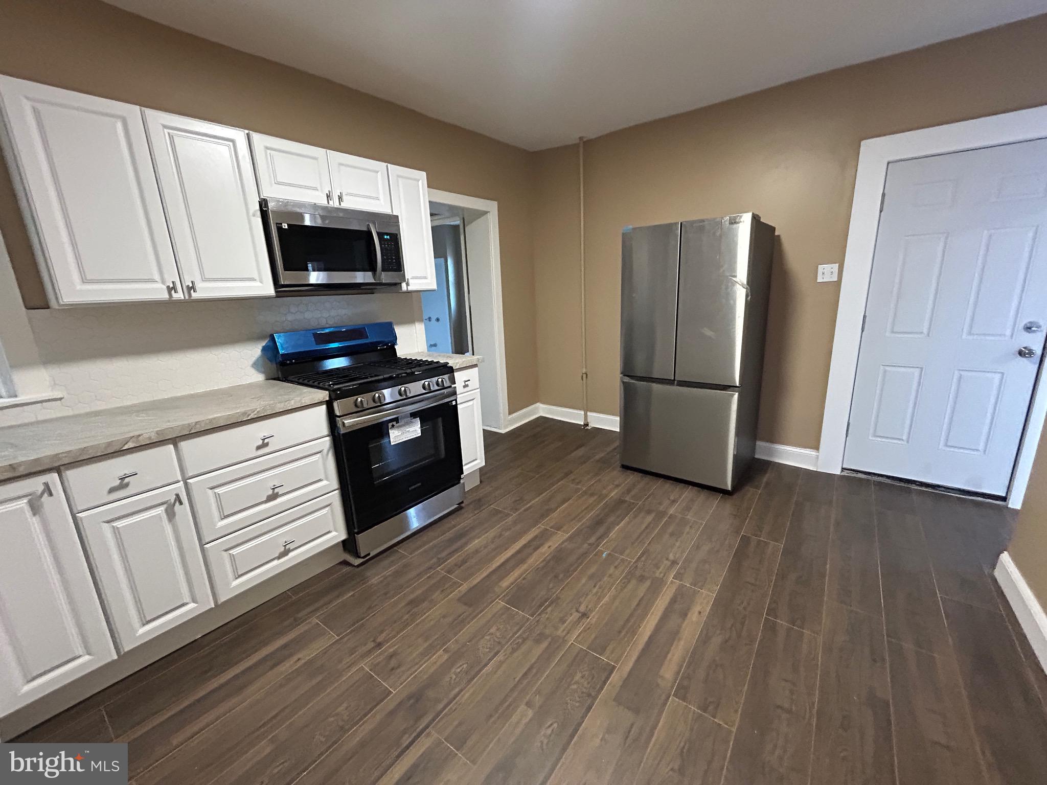 1428 West State Street Trenton, NJ 08618 - Photo 5 of 26 a kitchen with a refrigerator stove and wooden cabinets