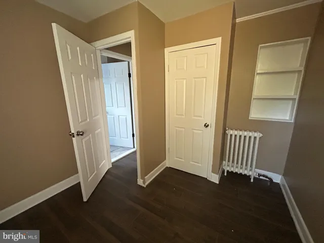 an empty room with wooden floor and a door