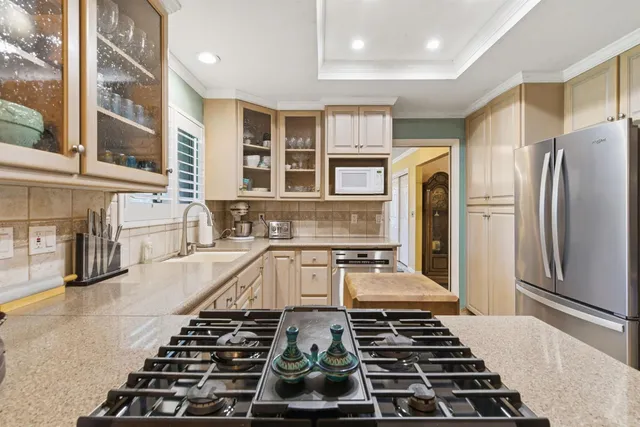 a kitchen with kitchen island granite countertop a stove and a refrigerator