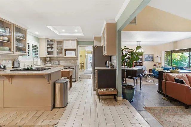 a living room with stainless steel appliances granite countertop wooden floor a couch and a view of living room