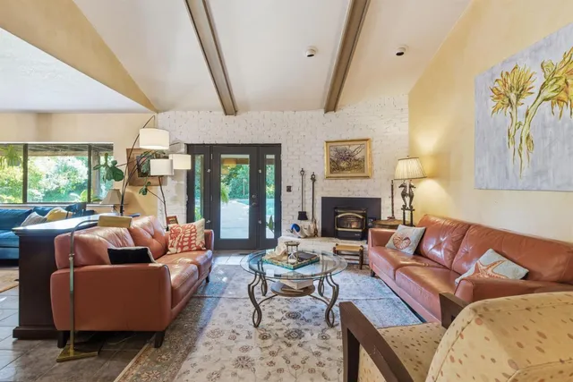 a living room with furniture fireplace and a large window