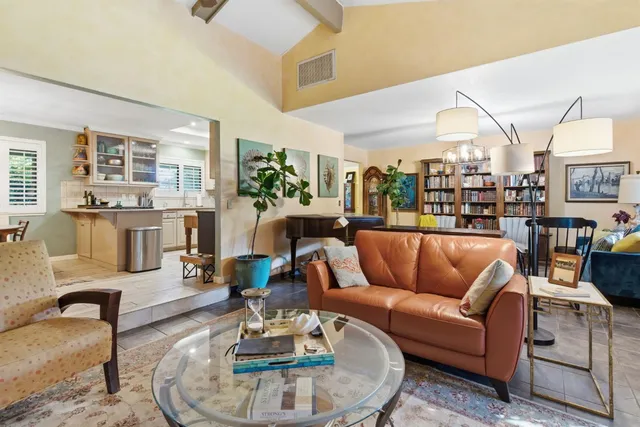 a living room with furniture kitchen view and large windows