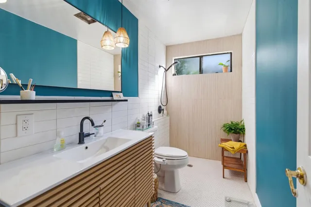 a bathroom with a sink a toilet and a mirror